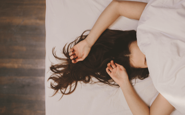 ベッドで横になる女性